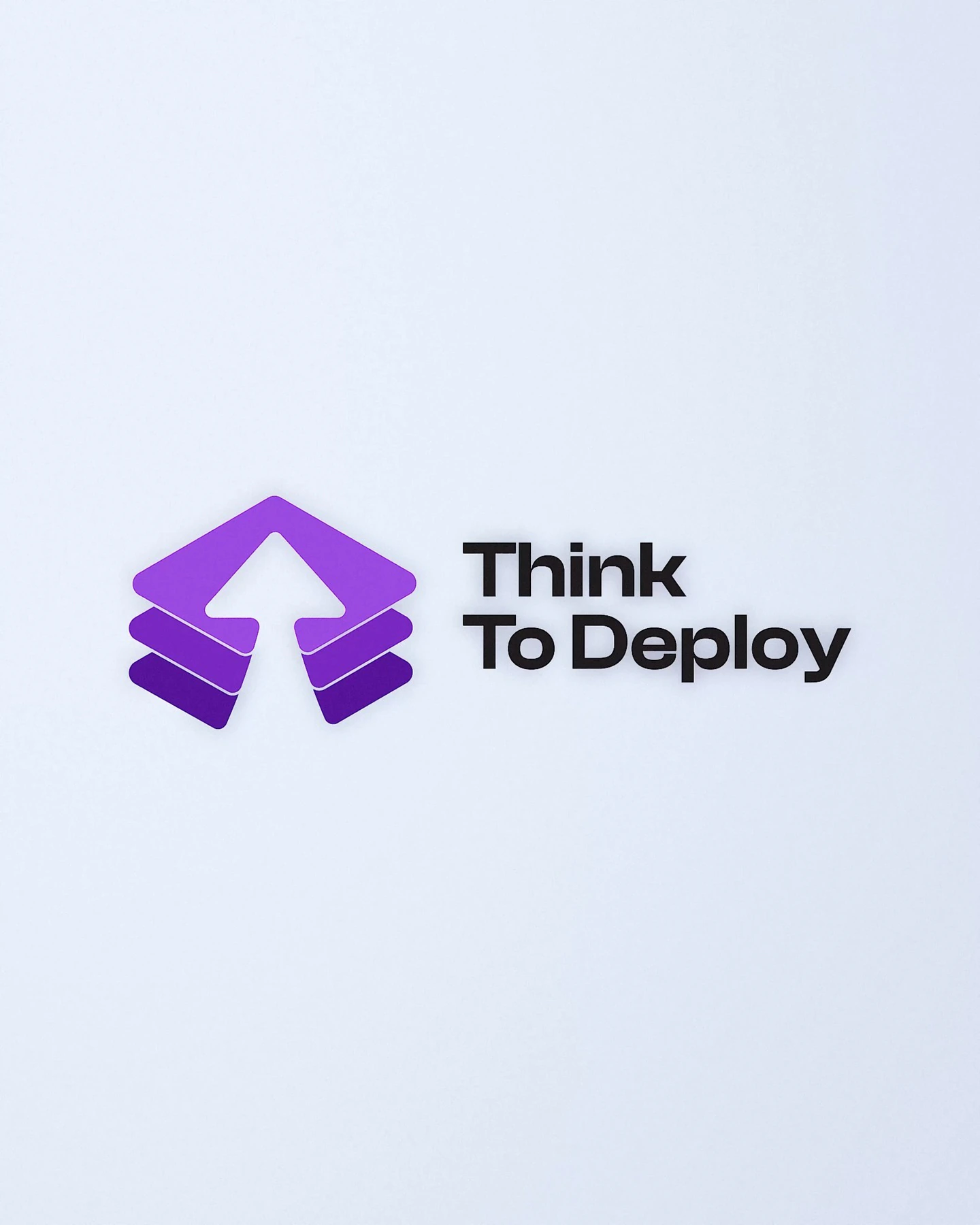 Dimensional violet arrow symbol and black Think To Deploy wordmark on a pale blue background.